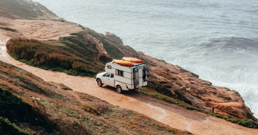 Foto van een camper op een route langs de kust